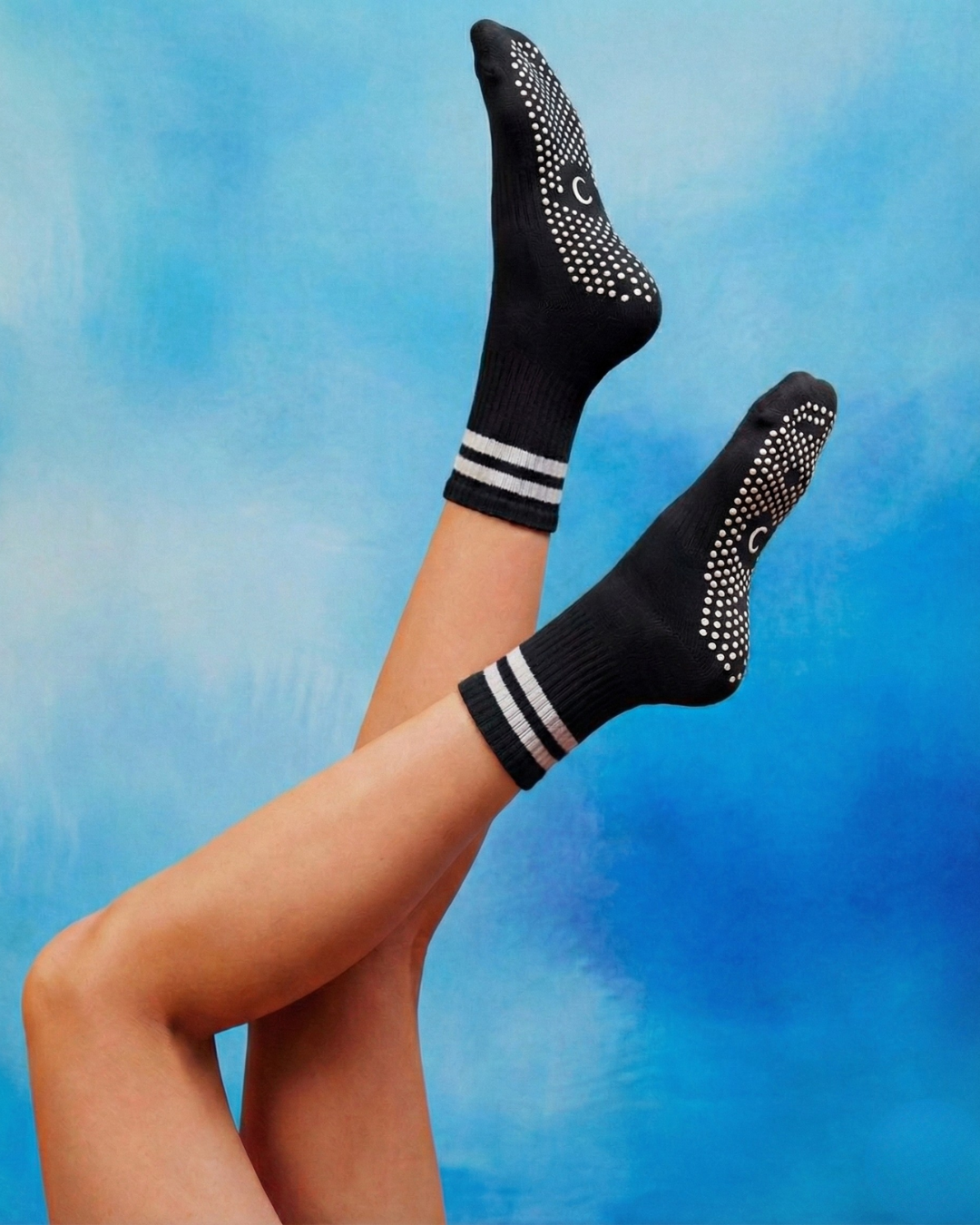 centered brand black crew pilates grip socks with white stripes.