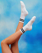centered. brand white crew pilates grip socks with black stripes.