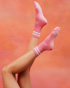 Rose pink pilates grip socks with white stripes centered logo.