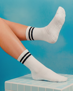 Non-slip silicone grip sole detail on white centered. socks.