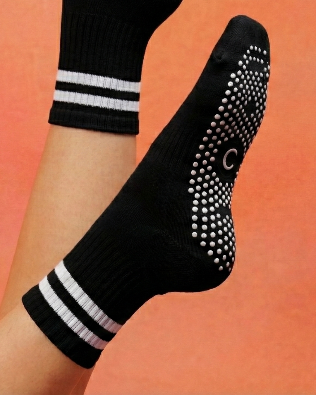 Non-slip silicone grip sole detail on centered socks. 