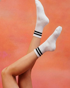 centered. brand white crew pilates grip socks with black stripes.